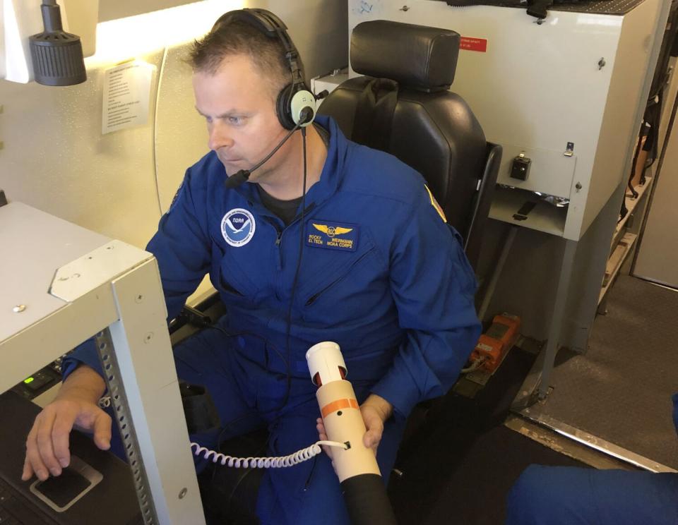 A man prepares to deploy a dropsonde from a jet over an atmospheric river.