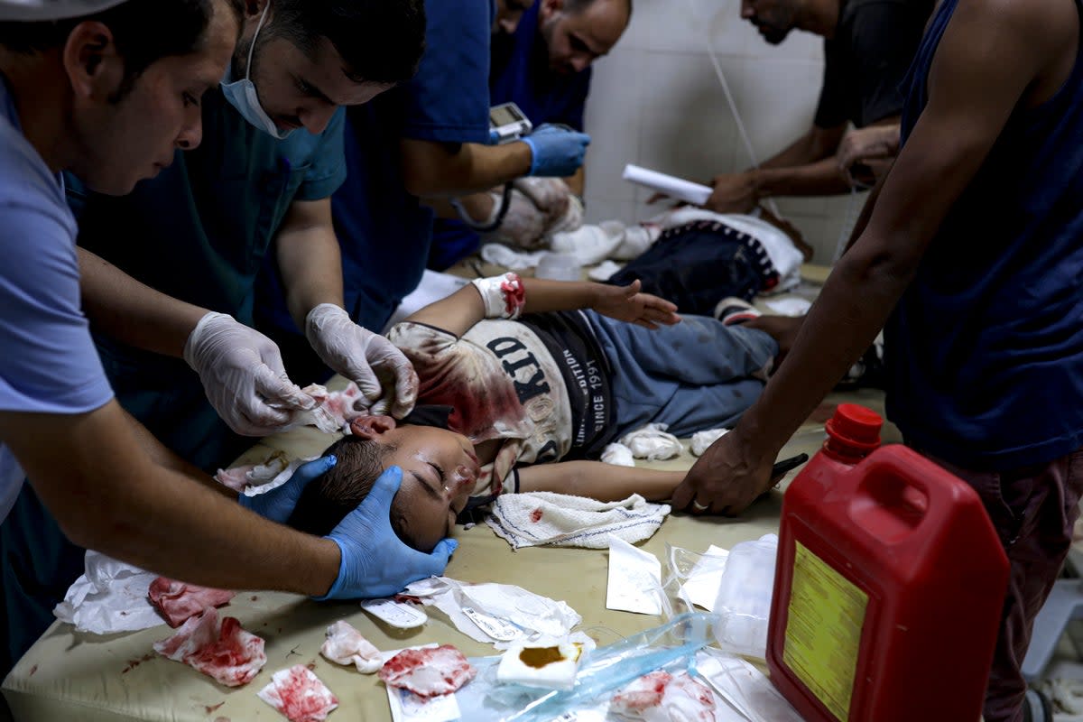 A Palestinian boy wounded in the Israeli bombardment of the Gaza Strip is treated in a hospital in Khan Younis (AP)