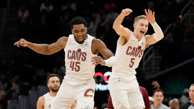 Cleveland Cavaliers guards Donovan Mitchell (45) and Sam Merrill (5) celebrate after a 3-point basket by Merrill in overtime against the Houston Rockets, Monday, Dec. 18, 2023, in Cleveland. The former Bountiful High and Utah State star is now doing his thing for the Cavs.