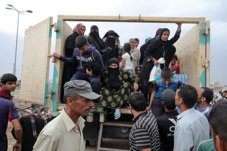 Displaced Iraqi people get out from a truck as the battle between the Iraqi Counter Terrorism Service and Islamic State militants continues nearby, in western Mosul, Iraq, April 23, 2017. REUTERS/Marko Djurica