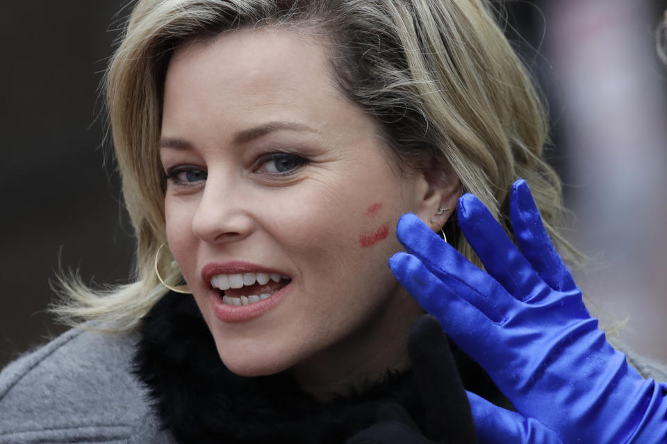 Lipstick is wiped from the cheek of actor and director Elizabeth Banks after she was kissed by a student actor in drag during a parade through Harvard Square to honor her as the 2020 Woman of the Year by Harvard University's Hasty Pudding Theatricals, Friday, Jan. 31, 2020, in Cambridge, Mass. (AP Photo/Elise Amendola)