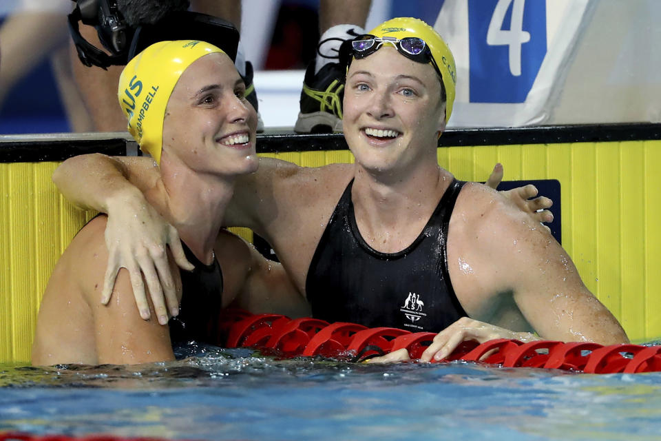 FILE - In this April 6, 2018, file photo, Australia's Cate Campbell, right, embraces her sister Bronte Campbell after their women's 50m freestyle semifinal at the Aquatic Centre during the 2018 Commonwealth Games on the Gold Coast, Australia. Even before the coronavirus pandemic, the Australian swimming siblings have had their share of health concerns. (AP Photo/Rick Rycroft, File)