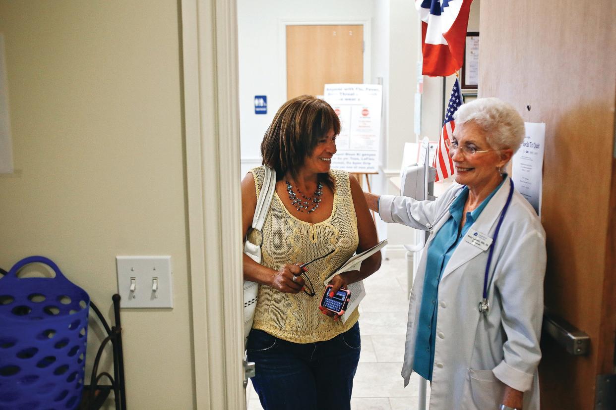 Neighborhood Health Clinic founder Nancy Lascheid, right, welcomes Debra Knight as she enters the clinic in Naples on Thursday, Sept. 12, 2013.