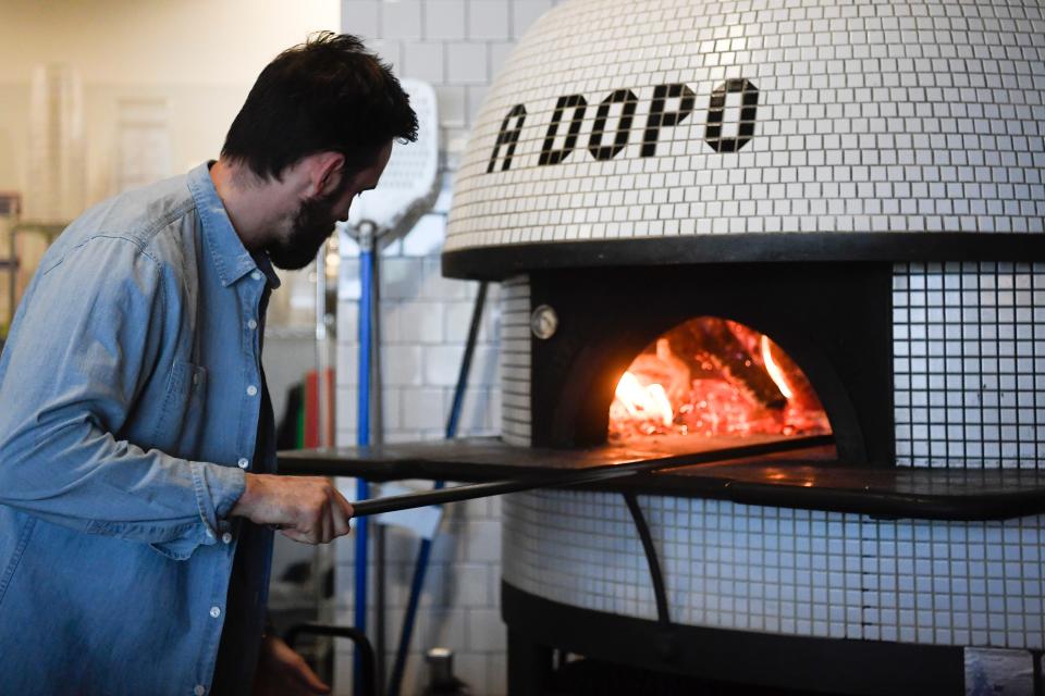 Brian Strutz of A Dopo Sourdough Pizza tends to the oven's fire.