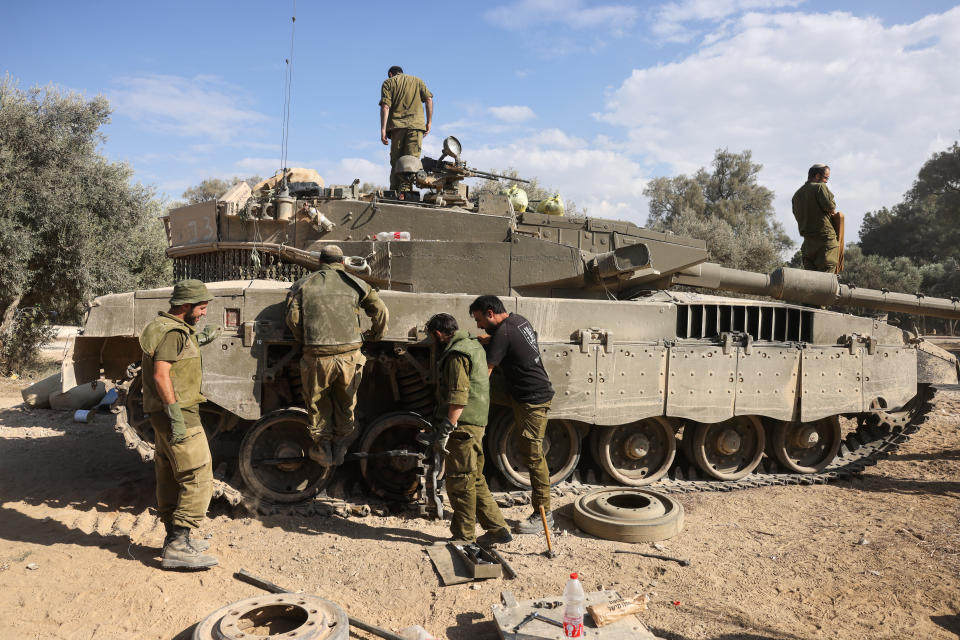 以色列士兵17日在加薩邊境附近對一輛坦克進行維護。（法新社）