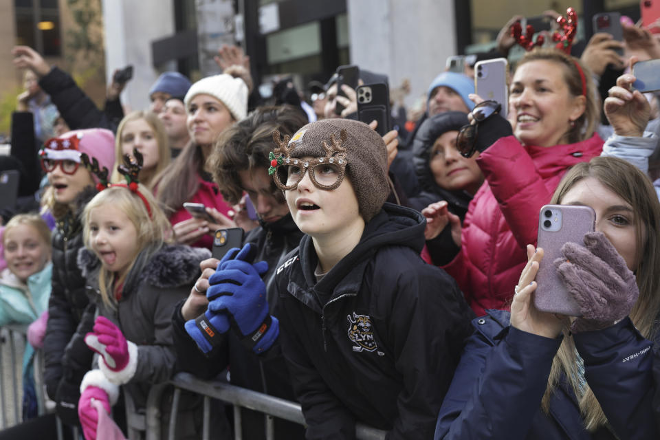 Spectators watch floats and balloons pass by on Sixth Avenue during the Macy's Thanksgiving Day Parade, Thursday, Nov. 24, 2022, in New York. (AP Photo/Jeenah Moon)