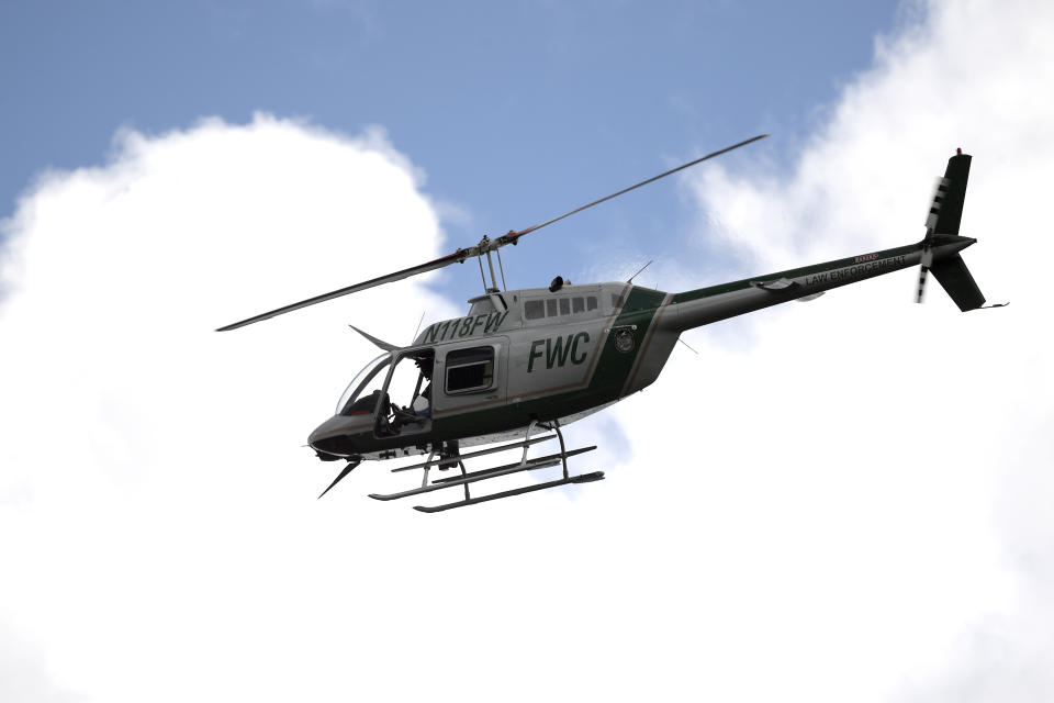 A Florida Fish and Wildlife Conservation Commission helicopter flies overhead during a search for Brian Laundrie in the Carlton Reserve, Tuesday, Sept. 21, 2021, in Venice, Fla. Laundrie is a person of interest in the disappearance of his girlfriend, Gabrielle "Gabby" Petito. (AP Photo/Phelan M. Ebenhack)