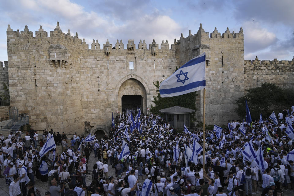 Israelis dance and wave national flags during a march marking Jerusalem Day, an Israeli holiday celebrating the capture of east Jerusalem in the 1967 Mideast war, in front of the Damascus Gate of Jerusalem's Old City, Thursday, May 18, 2023. (AP Photo/Mahmoud Illean)