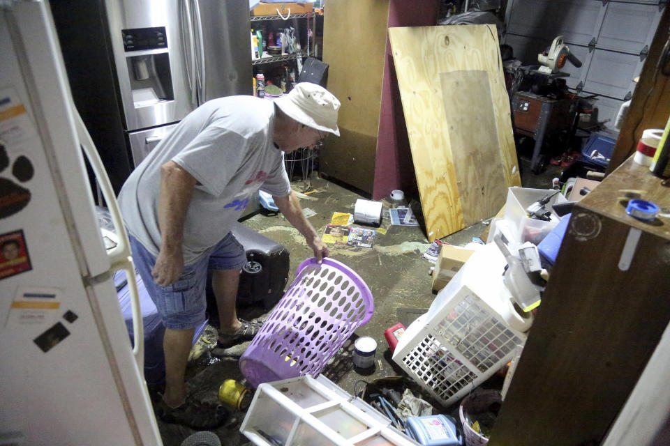 Garry Sears, 75, starts the process of cleaning up his garage which was tossed by more than a foot of storm surge which entered the garage overnight at his home on Shore Drive E. Thursday, Nov. 12, 2020, in Oldsmar, Fla., in the aftermath of Tropical Storm Eta. The storm dumped torrents of blustery rain on Florida's west coast as it moved over Florida after making landfall north of the heavily populated Tampa Bay area Thursday morning. (Douglas R. Clifford/Tampa Bay Times via AP)