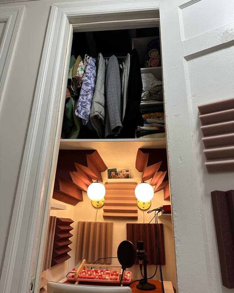 Clothes organized on top of small closet turned into office.