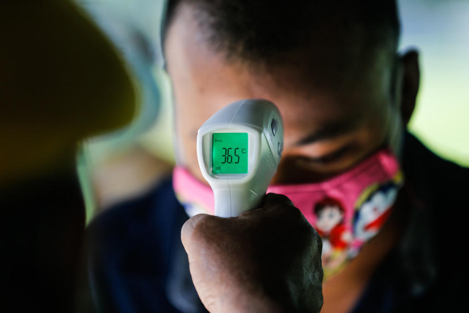 A foreign worker has his temperature taken during a Covid-19 screening exercise at Padang Polo, George Town May 14, 2020. — Picture by Sayuti Zainudin