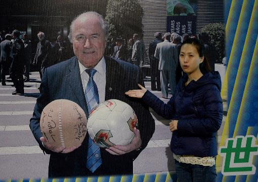 Una imagen del presidente de la FIFA, el suizo Sepp Blatter, sosteniendo dos balones, uno de 'Cuju' y otro de fútbol moderno, está expuesta en en el Museo de Fútbol de Linzi, en la ciudad china de Zibo, el 15 de mayo de 2014 (AFP/Archivos | Mark Ralston)