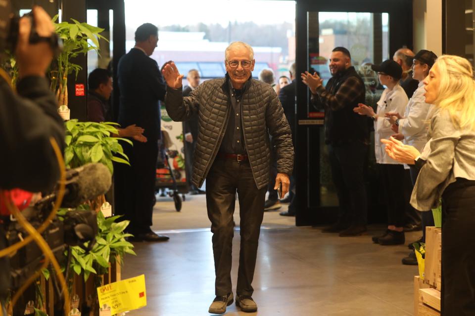 Joe Cappello of East Rochester is the first to shop and walk through the doors of  Whole Foods Market.  He waved to the employees who were applauding customers as they walked through.