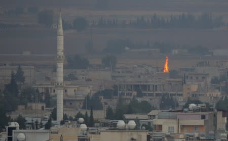 Fire is seen in the Syrian town of Ras al-Ain as seen from the Turkish border town of Ceylanpinar