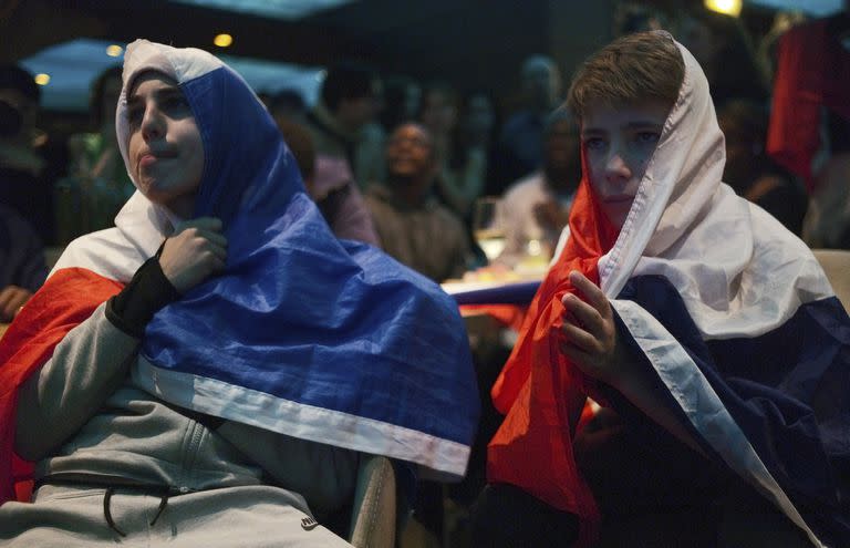 Decepcionados aficionados franceses de fútbol reaccionan mientras ven el partido final de la Copa del Mundo de fútbol entre Argentina y Francia, que se muestra en directo por televisión en un café, en París, el domingo 18 de diciembre de 2022.
