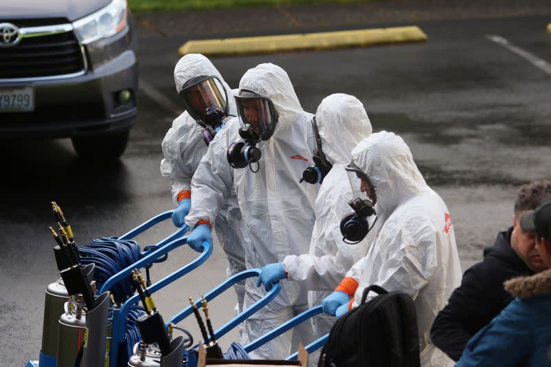 Members of a Servpro cleanup crew wear hazardous material suits as they prepare to enter Life Care Center of Kirkland, the Seattle-area nursing home at the epicenter of one of the biggest coronavirus outbreaks in the United States, in Kirkland