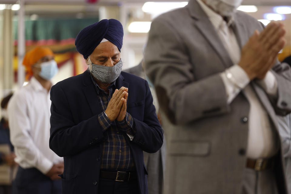 Sikhs pray during Vaisakhi celebrations at Guru Nanak Darbar of Long Island, Tuesday, April 13, 2021 in Hicksville, N.Y. Sikhs across the United States are holding toned-down Vaisakhi celebrations this week, joining people of other faiths in observing major holidays cautiously this spring as COVID-19 keeps an uneven hold on the country. (AP Photo/Jason DeCrow)