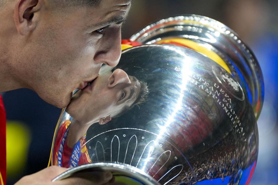 Spain's Alvaro Morata kisses the trophy after winning the final match between Spain and England at the Euro 2024 soccer tournament in Berlin, Germany, Sunday, July 14, 2024. (AP Photo/Martin Meissner)