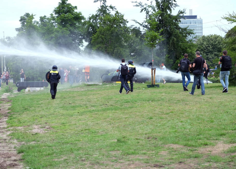 Police use a water cannon during a demonstration targeting the government’s handling of the coronavirus crisis, in Malieveld, the Hague, Netherlands, Sunday, June 21, 2020. Dutch police charged hundreds of what they called soccer fans with horses and a water cannon in the center of The Hague Sunday and warned people to stay away from the city center. (AP Photo/Michael Corder)
