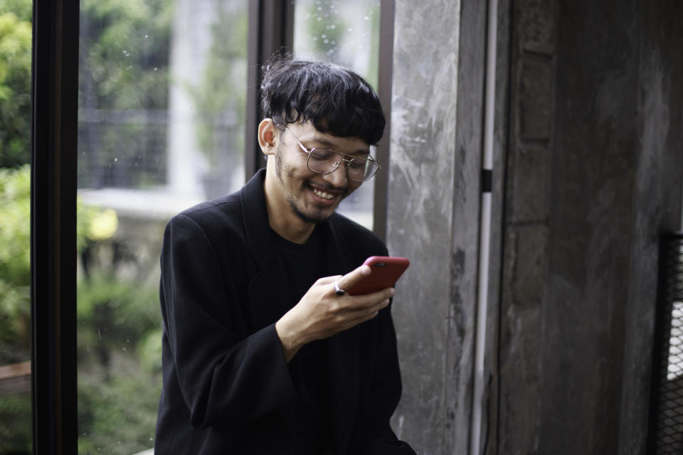 Man laughs at his cell phone