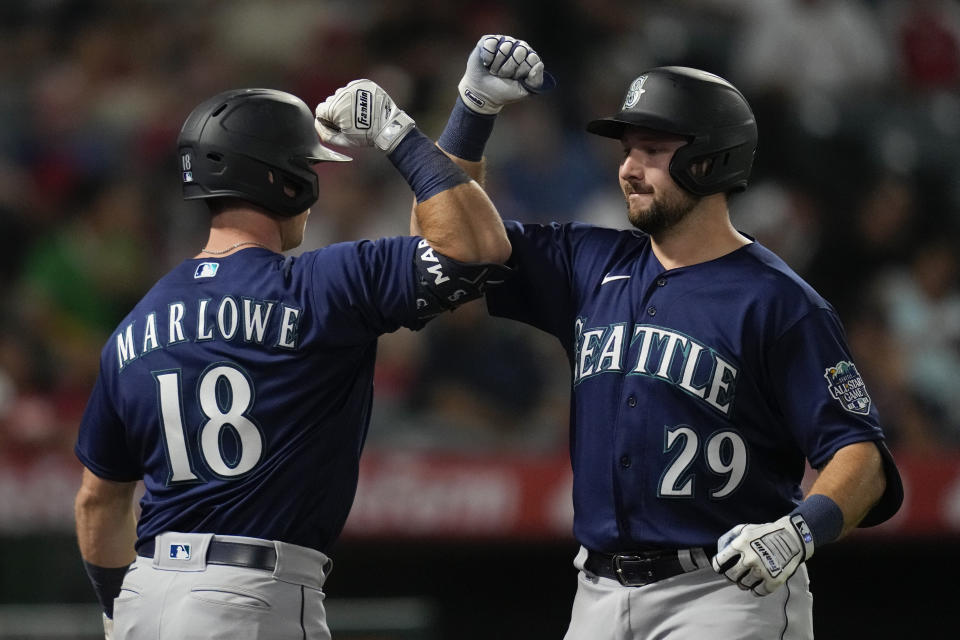 Seattle Mariners designated hitter Cal Raleigh (29) celebrates with Cade Marlowe (18) after hitting a home run during the ninth inning of a baseball game against the Los Angeles Angels in Anaheim, Calif., Friday, Aug. 4, 2023. (AP Photo/Ashley Landis)