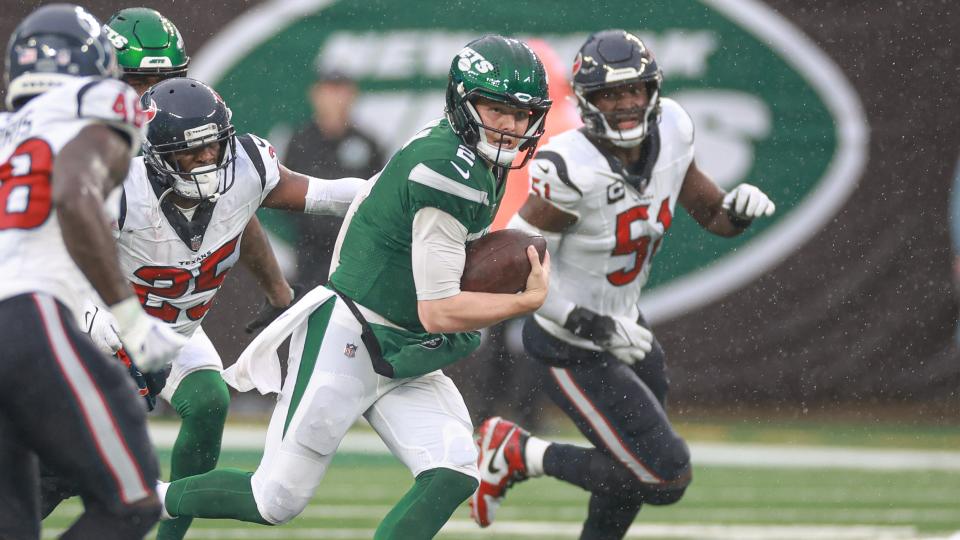 Dec 10, 2023; East Rutherford, New Jersey, USA; New York Jets quarterback Zach Wilson (2) is pursued by Houston Texans cornerback Desmond King II (25) during the second half at MetLife Stadium. Mandatory Credit: Vincent Carchietta-USA TODAY Sports