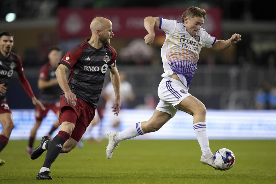 Orlando City forward Duncan McGuire, right, drives past Toronto FC midfielder Michael Bradley on his way to scoring a goal during the second half of an MLS soccer match in Toronto on Saturday, Oct. 21, 2023. (Nathan Denette/The Canadian Press via AP)