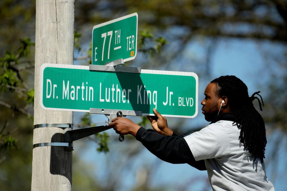 Public works employee Jerry Brooks changes a street sign from The Paseo to Dr. Martin Luther King Jr. Blvd. in Kansas City, Missouri, April 20, 2019.