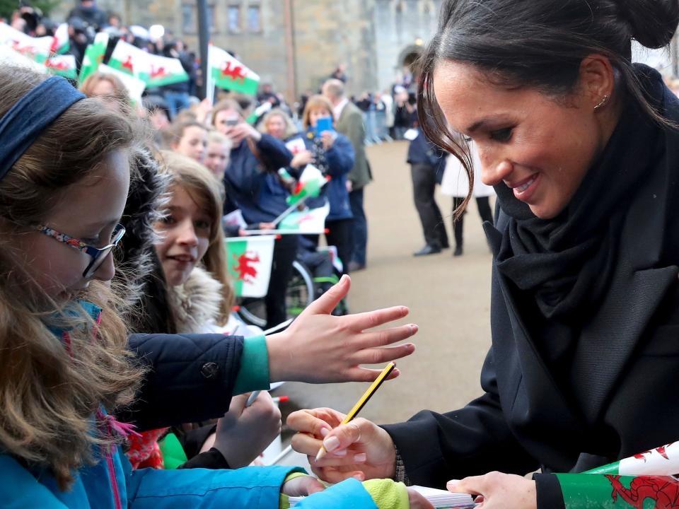 Meghan Markle signs an autograph