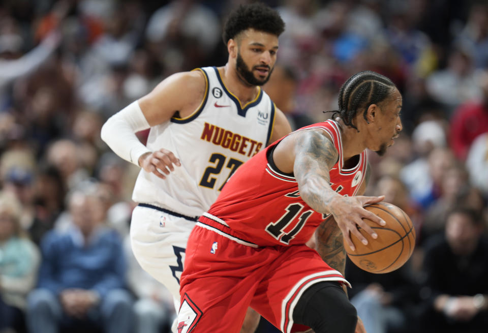 Chicago Bulls forward DeMar DeRozan, front, pulls in a loose ball as Denver Nuggets guard Jamal Murray defends in the first half of an NBA basketball game Wednesday, March 8, 2023, in Denver. (AP Photo/David Zalubowski)