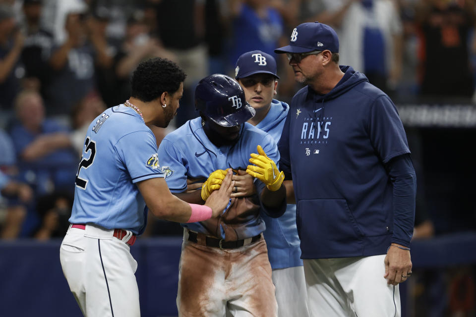 Tampa Bay Rays' Randy Arozarena, center, is restrained by pitching coach Kyle Snyder, right, and teammate Jose Siri after being by a pitch from the New York Yankees during the eighth inning of a baseball game Sunday, Aug. 27, 2023, in St. Petersburg, Fla. (AP Photo/Scott Audette)