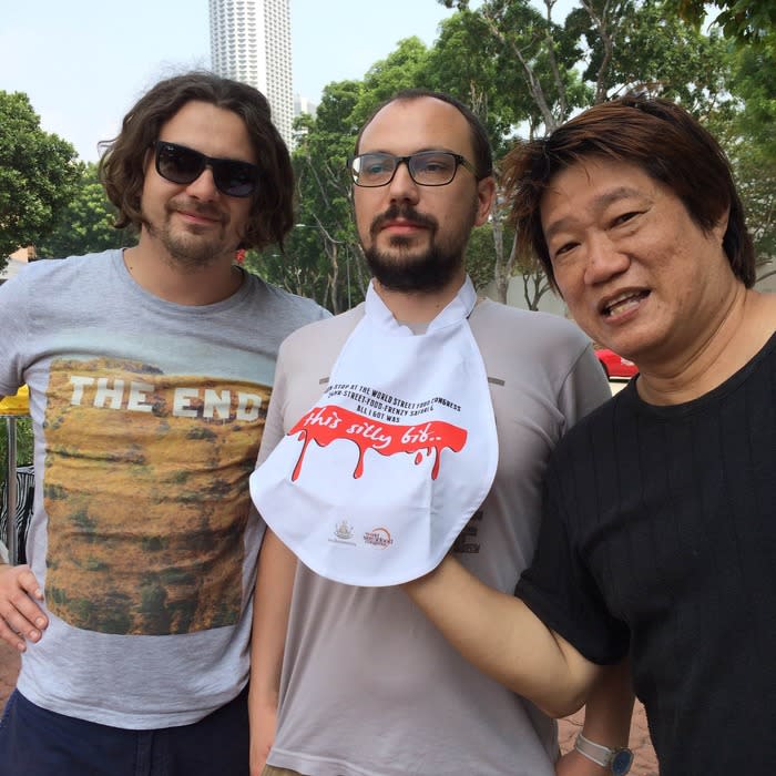 Fresh graduate: KF Seetoh, the makan guru from Makan Sutra, posed with Russian journalists, parading his graduation bib, a symbol for participating in the world's first ever 24-hour street food rally.