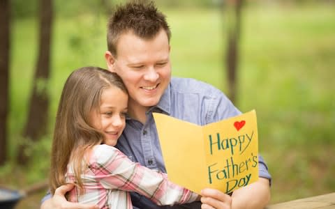 father excitedly receives a homemade card from his daughter - Credit: E+