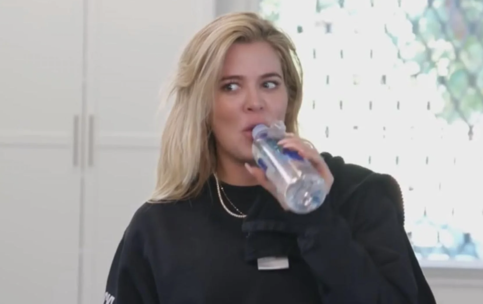 A screenshot of Khloe Kardashian sipping from a water bottle and giving someone an incredulous side-eye