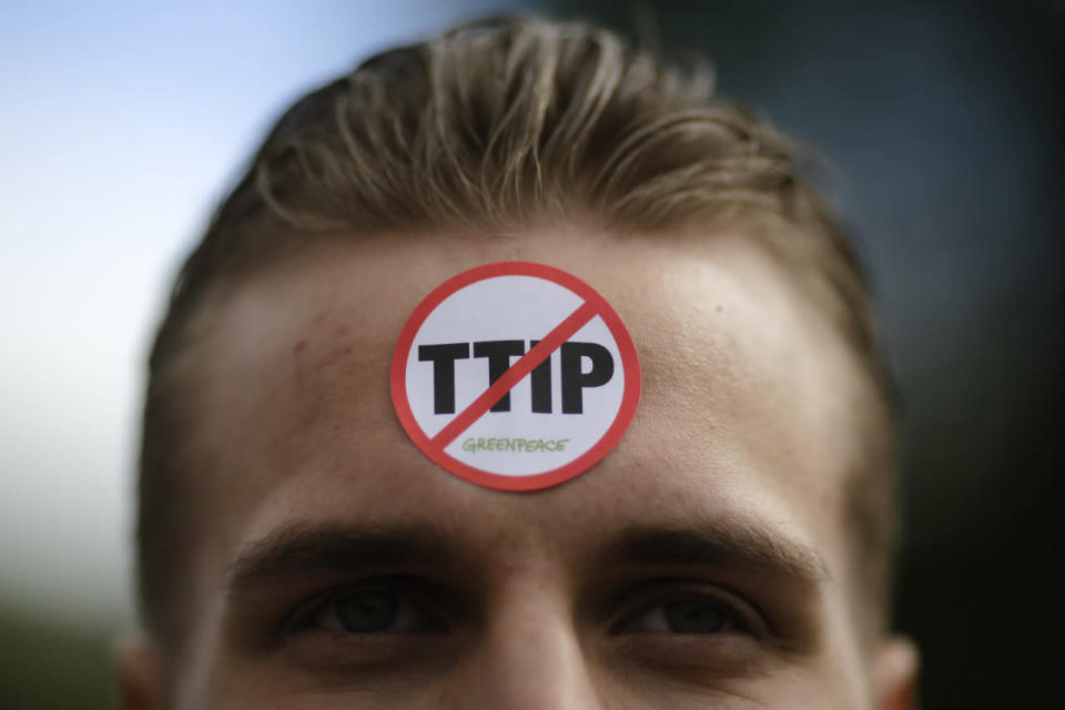 A man has a sticker by the environment organization Greenpeace against TIPP on his forehead during a protest against the planned Transatlantic Trade and Investment Partnership (TTIP) and the Comprehensive Economic and Trade Agreement (CETA) ahead of a visit by President Obama in Hanover, Germany, April 23, 2016. (Markus Schreiber/AP)