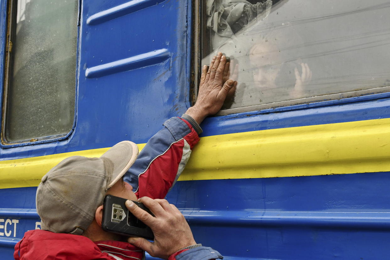 A child looking out the window of a train waiting to leave Kramatorsk, Ukraine, on Wednesday speaks on the phone as he says goodbye to a relative.