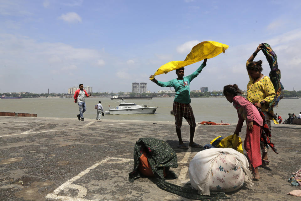 A man holds a clothing to dry in the wind after bathing in the Hooghly River in Kolkata, India, Saturday, May 4, 2019. Cyclone Fani tore through India's eastern coast on Friday as a grade 5 storm, lashing beaches with rain and winds gusting up to 205 kilometers (127 miles) per hour and affecting weather as far away as Mount Everest as it approached the former imperial capital of Kolkata. (AP Photo/Bikas Das)