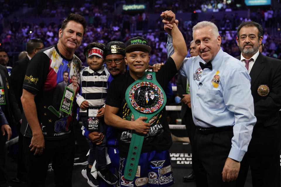 Isaac Cruz, center, celebrates after winning a WBC world lightweight title eliminator boxing match against Eduardo Ramirez, Sunday, Sept. 4, 2022, in Los Angeles. (AP Photo/Ashley Landis)