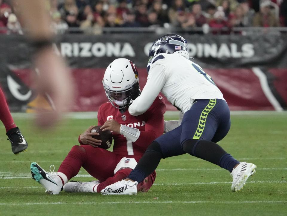 Arizona Cardinals quarterback Kyler Murray (1) is hit by Seattle Seahawks linebacker Devin Bush (0) after sliding during the fourth quarter at State Farm Stadium in Glendale on Jan. 7, 2024.