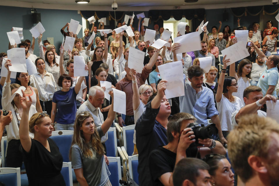 Theater staff brandish their resignation letters to Yuri Bondar, Belarusian Minister of Culture, not in the picture, in the Janka Kupala National Theater in Minsk, Belarus, Tuesday, Aug. 18, 2020. Several dozen people gathered in front of the theater to support the troupe that handed in their notice after the theater's director, Pavel Latushko, was fired. (AP Photo/Dmitri Lovetsky)