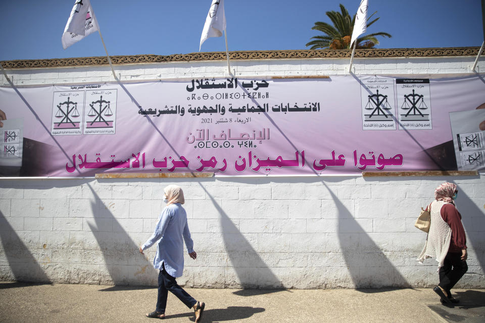 People walk past electoral banners in Rabat, Morocco, Thursday, Sept. 2, 2021, days before the upcoming legislative and regional elections. Millions of Moroccans head to the polls on Sept. 8 to cast ballots in pivotal legislative and regional elections amid strict safety guidelines as the north African country is grappling with a new wave of COVID-19, driven mainly by the Delta variant. (AP Photo/Mosa'ab Elshamy)