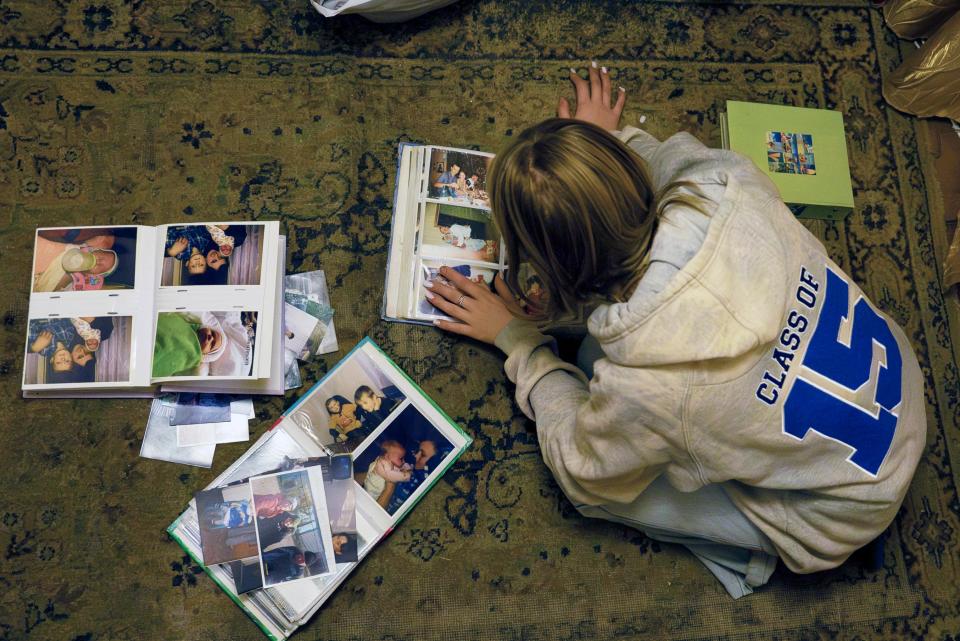 15-year-old Ksiusha Mukhovata shows pictures of her family in the village of Hroza near Kharkiv (AP)