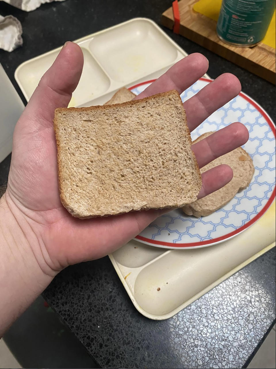 Coles shopper holding slice of wholemeal bread.