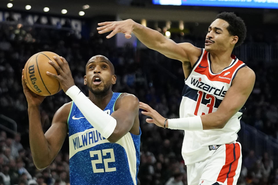 Milwaukee Bucks' Khris Middleton (22) looks to shoot past Washington Wizards' Jordan Poole (13) during the first half of an NBA basketball game Friday, Nov. 24, 2023, in Milwaukee. (AP Photo/Aaron Gash)