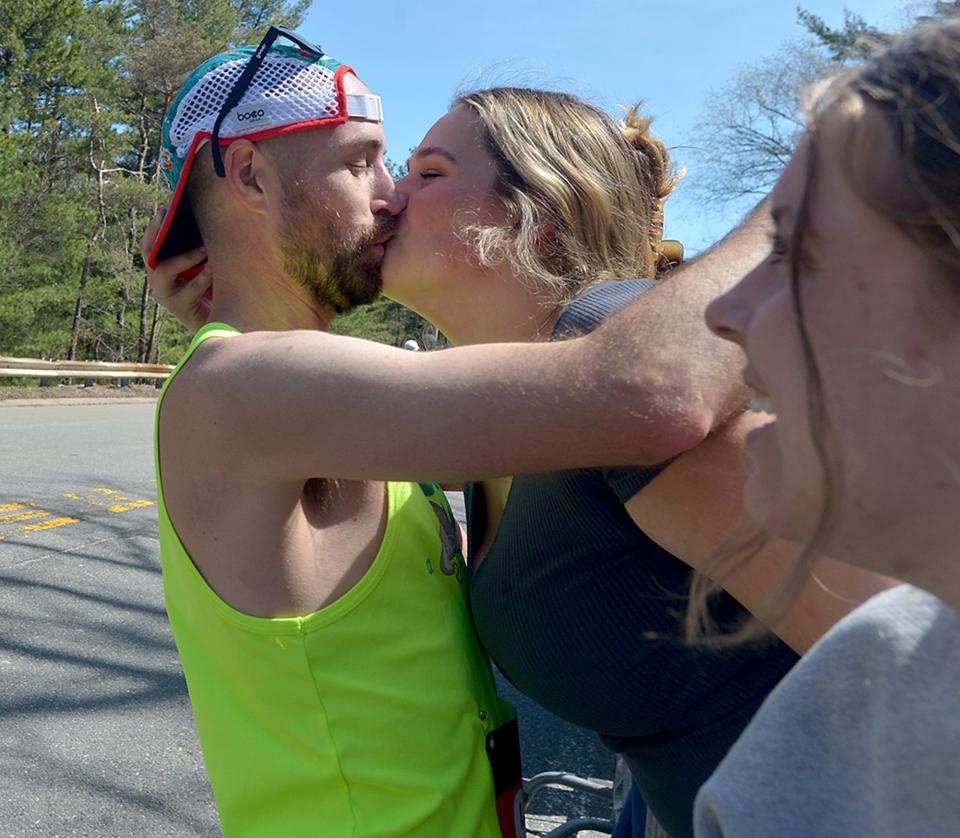 Chloe Theriault, a Wellesley College sophomore from Arizona, gets a kiss from runner Ryan Barrett, of Charleston, S.C., in the scream tunnel at Wellesley College during the 126th Boston Marathon, April 18, 2022. 