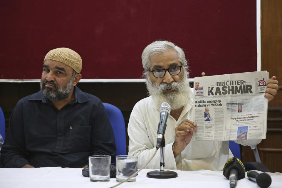 Indian activist and education reformer Sandeep Pandey, right, holds a local daily newspaper of Srinagar, as he addresses a press conference in New Delhi, India, Saturday, Oct. 5, 2019. Pandey and a U.S. senator were barred from visiting Indian-administered Kashmir, the disputed Himalayan territory where at least 10 people were injured Saturday in a grenade blast as a government security and communications lockdown entered a third month. Also seen is Faisal Khan of Khudai Khidmatgar, an organization founded by freedom fighter Khan Abdul Gaffar Khan. (AP Photo/Altaf Qadri)
