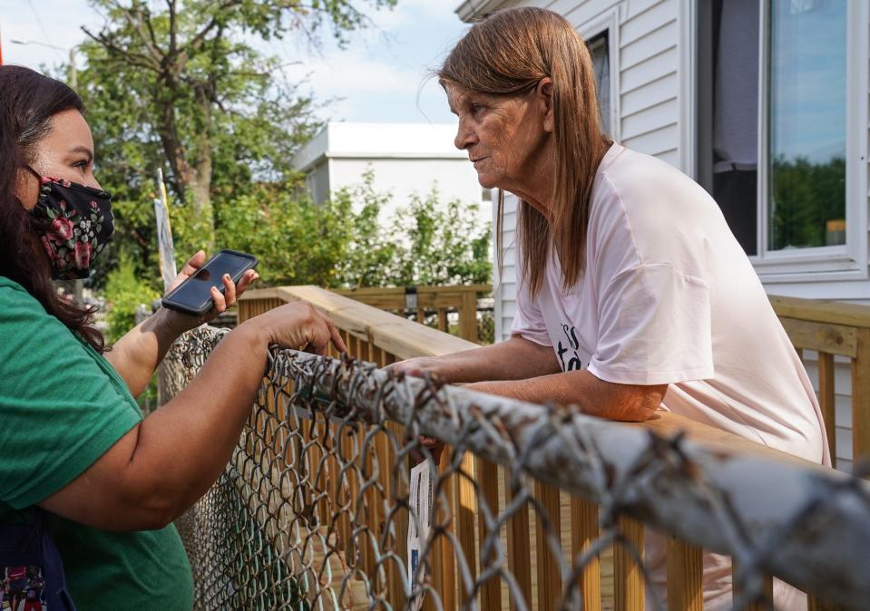 Sharon Bayn, right, 62, of Detroit talks with Congress of Communities parent advocate Cristian Aranda outside Bayn's home Aug. 26. Bayn wanted to figure out how to receive a child tax credit for her 15-year-old grandson.