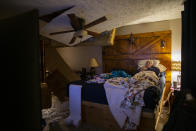 Lee Brewer watches the news from his bedroom as the ceiling hangs after it was damaged by a massive explosion in west Houston on Friday, Jan. 24, 2020, in Houston. A massive explosion early Friday leveled a warehouse in Houston and damaged nearby buildings and homes, rousing frightened people from their sleep miles away. (Marie D. De Jesús/Houston Chronicle via AP)