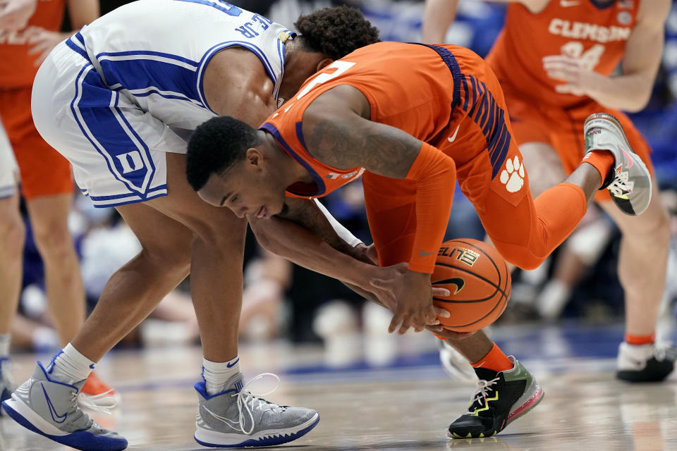 Duke forward Wendell Moore Jr. (0) and Clemson guard Al-Amir Dawes (2) chase a loose ball during the first half of an NCAA college basketball game in Durham, N.C., Tuesday, Jan. 25, 2022. (AP Photo/Gerry Broome)