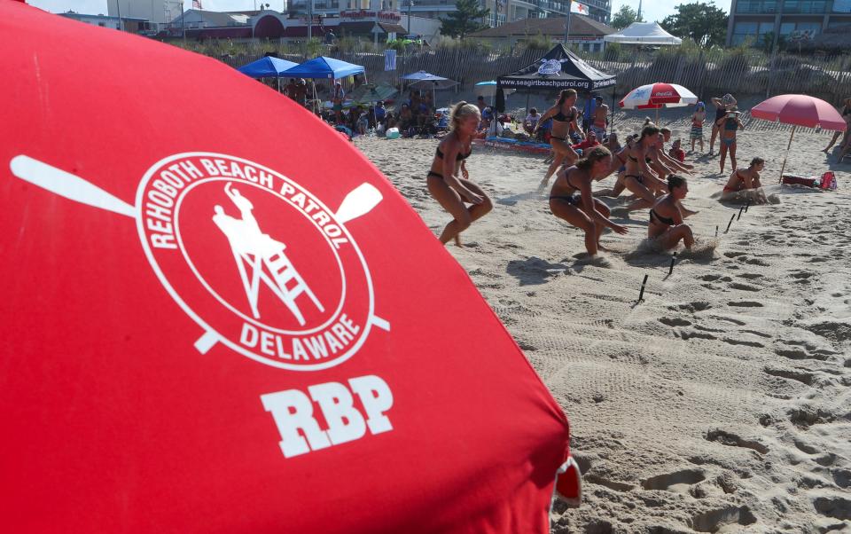 Racers compete in a heat of the beach flags competition in the Mid-Atlantic Regional Lifeguard Championships in Rehoboth Beach Wednesday, July 13, 2022.